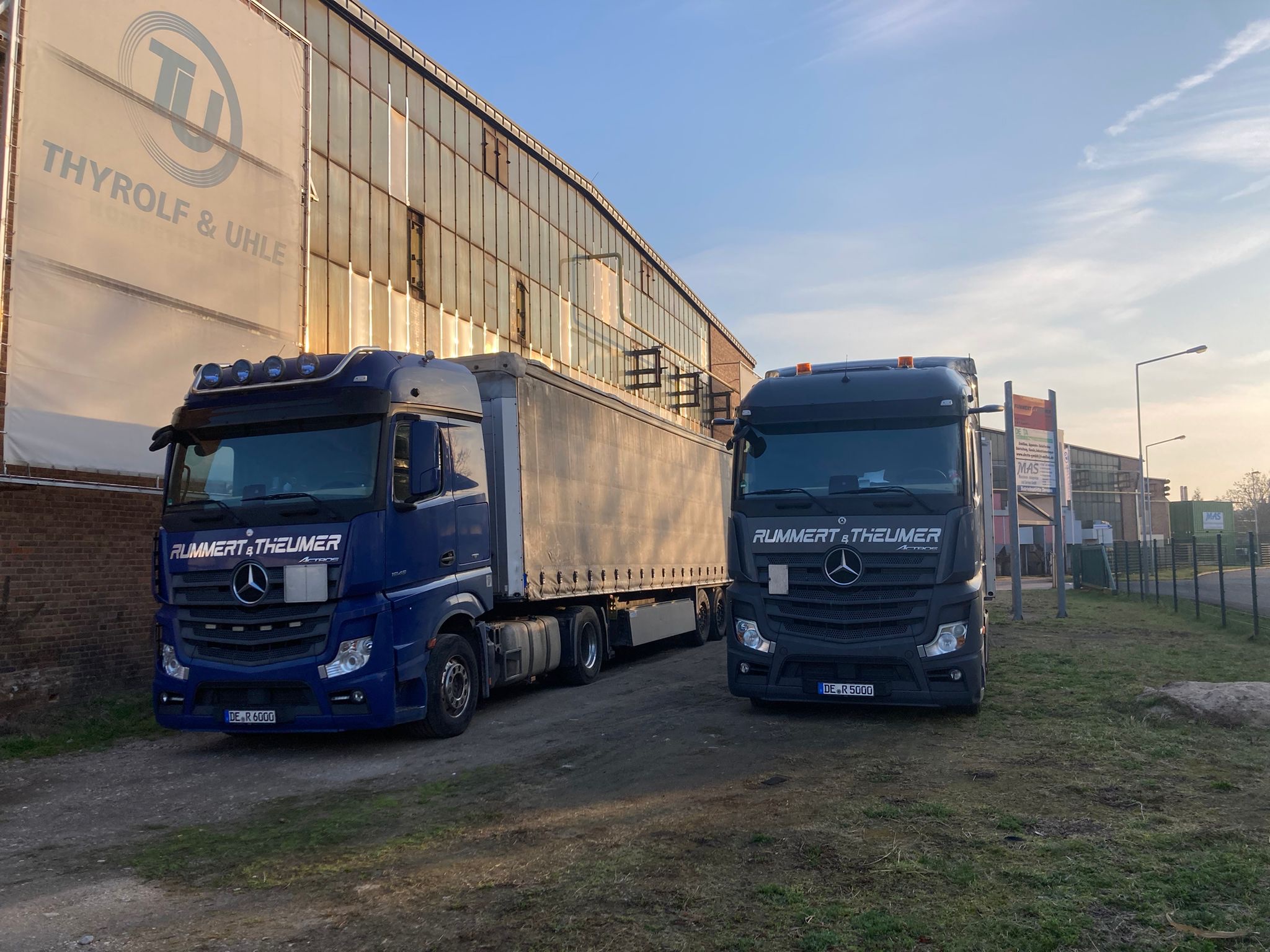 Zwei LKW von Rummert & Theumer für Transport & Logistik der Taxi Dessau GmbH auf einem Betriebsgelände